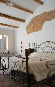 a bedroom with a bed in a room with white walls at La Casetta nel Borgo in Faenza