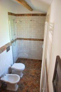 een badkamer met 2 toiletten en een douche bij La Casetta nel Borgo in Faenza