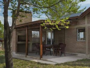 un patio con mesa y sillas frente a una casa en Casa con pileta en Villa General Belgrano en Villa General Belgrano