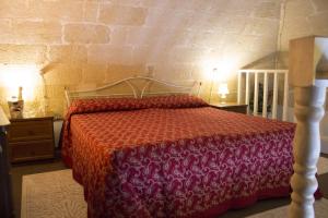 a bedroom with a bed with a red bedspread at La Ferula in Laterza