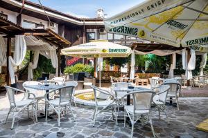 an outdoor patio with tables and chairs and umbrellas at Hotel Varosha in Lovech
