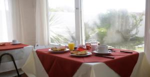 una mesa con platos de comida en un mantel rojo en Perla del Este, en La Paloma