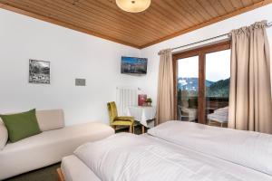 a hotel room with a couch, chair and a window at Pension Margarete in Zell am See