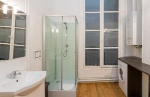 a bathroom with a glass shower and a sink at Opéra Septembre in Paris