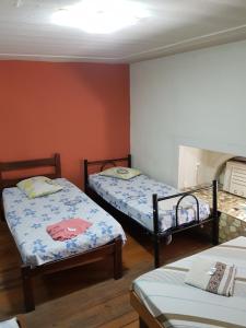 a bedroom with two beds and a fireplace at Hotel Cabo Finisterra in Rio de Janeiro