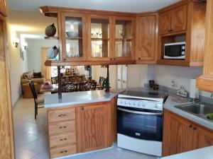 uma cozinha com armários de madeira e um forno com placa de fogão em Breezy Apts em Saint Philip