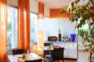 a kitchen with a table and chairs and a microwave at Hotel Mirage in Marina di Pietrasanta