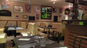 a dining room with tables and chairs in a restaurant at Logis de L'Europe Restaurant Le Cepage in Corbigny