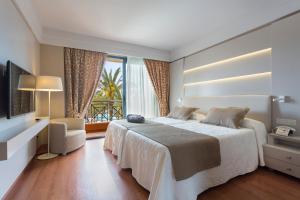 une chambre avec un grand lit et une grande fenêtre dans l'établissement Hipotels Hipocampo Palace & Spa, à Cala Millor