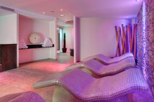 une chambre avec des chaises violettes et un mur dans l'établissement Hipotels Hipocampo Palace & Spa, à Cala Millor
