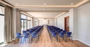 une salle de conférence avec des chaises bleues et un écran dans l'établissement Hipotels Hipocampo Palace & Spa, à Cala Millor 37 autres photos