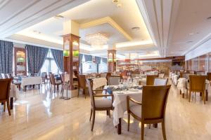 un restaurant avec des tables et des chaises dans une salle dans l'établissement Hipotels Hipocampo Palace & Spa, à Cala Millor