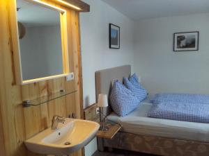 a bathroom with a sink and a bed with a mirror at Oberbichlgut in Flachau