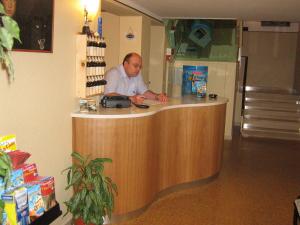 Ein Mann steht an einem Tresen in einem Laden. in der Unterkunft Hotel Toschi in Lido di Classe
