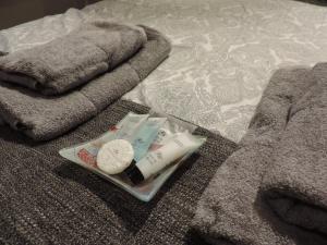a tray with a clock and towels on a bed at 4 Bed Farnborough Air Accommodation in Farnborough +20 photos