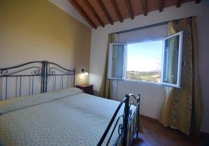 a bedroom with a bed and a window at Agriturismo L'Imposto in Pomarance