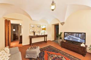 sala de estar con TV de pantalla plana y sofá en Via dei Fossi apartment, en Florencia