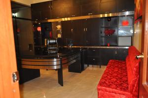 a living room with a table and a red chair at La Mansion Casa Hotel in Andahuaylas