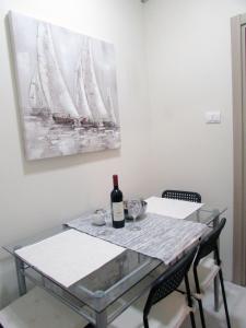 Apartment B&S في بلغراد: طاولة طعام مع زجاجة من النبيذ عليها
