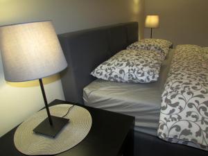 a bed with a hat on a table with a lamp at Apartment B&S in Belgrade