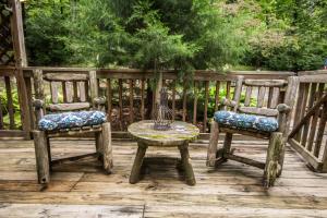 two chairs and a table on a wooden deck at Autumn Ridge- Cozy cabin in the Blue Ridge Mountains with a bubbly hot tub! in Big Meadows