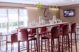 una mesa larga con sillas y copas de vino en Campanile Plaisir, en Plaisir