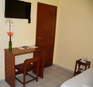 a room with a desk and a bed and a door at Hotel Transbrasil in Belém