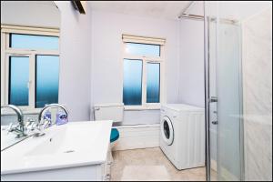 ダブリンにあるDrumcondra Junction Apartmentsの白いバスルーム(洗濯機、シャワー付)