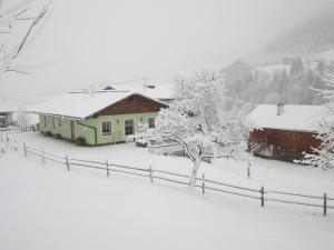dom pokryty śniegiem z płotem w obiekcie Appartement Greti w Schladming