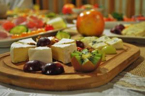 un plato de queso y fruta en una mesa en Hotel Zamkowy Młyn en Krapkowice