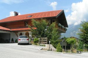 a car parked in front of a house at Landhaus Müller in Reith im Alpbachtal