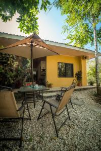 a table and chairs with an umbrella in front of a house at Blanconejo de Montezuma in Montezuma
