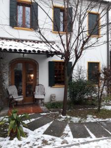 a house with two chairs and a door in the snow at Room Garden in Padova
