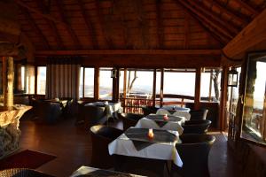 a dining room with tables and chairs and windows at Namibs Valley Lodge in Gamsberg Pass