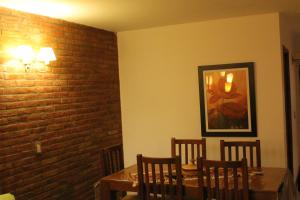a dining room with a table and a brick wall at Posta Del Cocodrilo in Pinamar