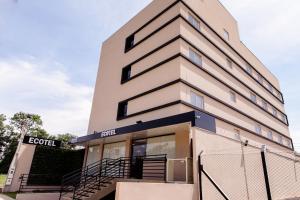 a tall building with a fence in front of it at Ecotel in Ribeirão Preto