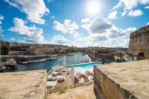 a view of a river with a pool and buildings at Cugo Gran Macina Malta in Senglea