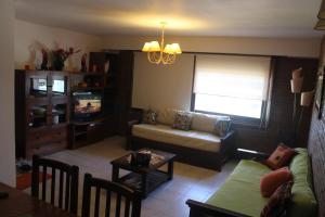 een woonkamer met een bank en een tv bij Posta Del Cocodrilo in Pinamar +2 foto's