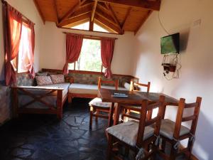 ein Wohnzimmer mit Sofa und Tisch in der Unterkunft Cabañas Aldea de Montaña in Lago Puelo
