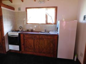 eine Küche mit einem weißen Kühlschrank und einer Spüle in der Unterkunft Cabañas Aldea de Montaña in Lago Puelo