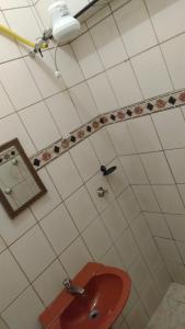 Un baño con un lavabo rojo y un espejo. en Hotel Paulista, en São Vicente 79 fotos más