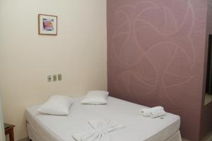 Una habitación con una cama con dos toallas encima. en Emburi Hotel, en Piratininga