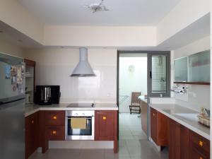 a kitchen with white counters and a stove top oven at Exodus Marina Cottage Apartment Ashdod in Ashdod