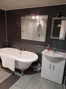 een badkamer met een bad, een wastafel en een bad bij Eilean Donan View in Dornie