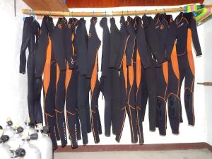 a group of ties hanging on a rack at Gustav's Place Silver Beach Dive Resort in Sablayan