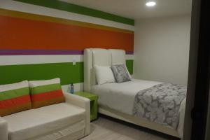 a bedroom with a bed and a chair in it at Andrea´s Hotel Boutique in Zacatlán