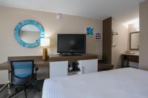 Habitación de hotel con cama y escritorio con TV. en Oasis Inn, en Beaufort