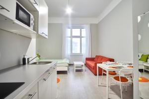 een keuken en een woonkamer met een rode bank bij HILD-2 Apartments | Budapest in Boedapest