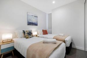 a hotel room with two beds and two lamps at Astra Apartments Newcastle Beach in Newcastle