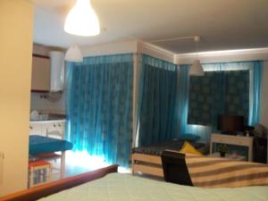 ポルティマンにあるAncora T0 Apartamento Praia da Rochaの青いカーテン付きのベッドルーム1室、ベッド1台が備わるベッドルーム1室が備わります。